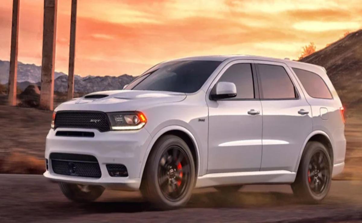 A sleek white SUV parked with a vibrant sunset in the background.