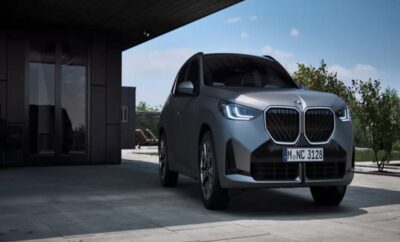 A sleek modern electric SUV parked under a shaded structure.