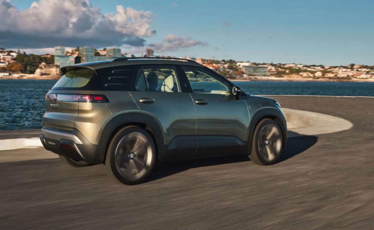 A sleek gray SUV driving along a coastal road with a scenic ocean view.