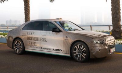 A sleek autonomous car parked by a palm tree in a cityscape.