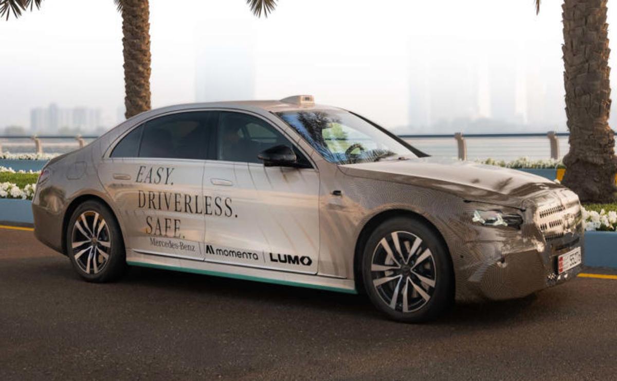 A sleek autonomous car parked by a palm tree in a cityscape.