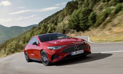 A red Mercedes-Benz coupe driving on a mountain road.
