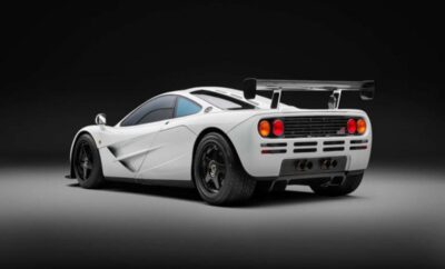 White sports car with sleek design and rear spoiler under studio lighting.