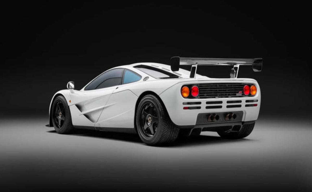 White sports car with sleek design and rear spoiler under studio lighting.