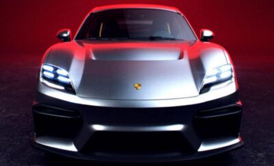 Front view of a sleek silver Porsche sports car with illuminated headlights.