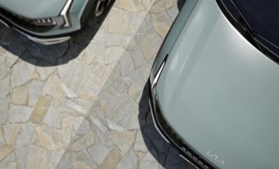 Two cars parked on a patterned stone driveway.