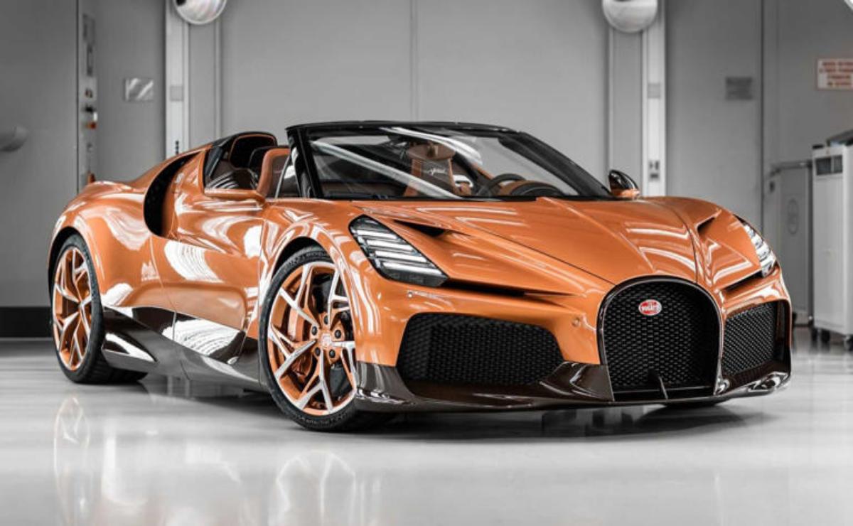 A sleek orange Bugatti sports car in a showroom.