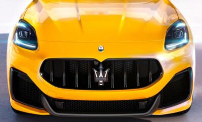 Close-up of a yellow Maserati grille with logo.