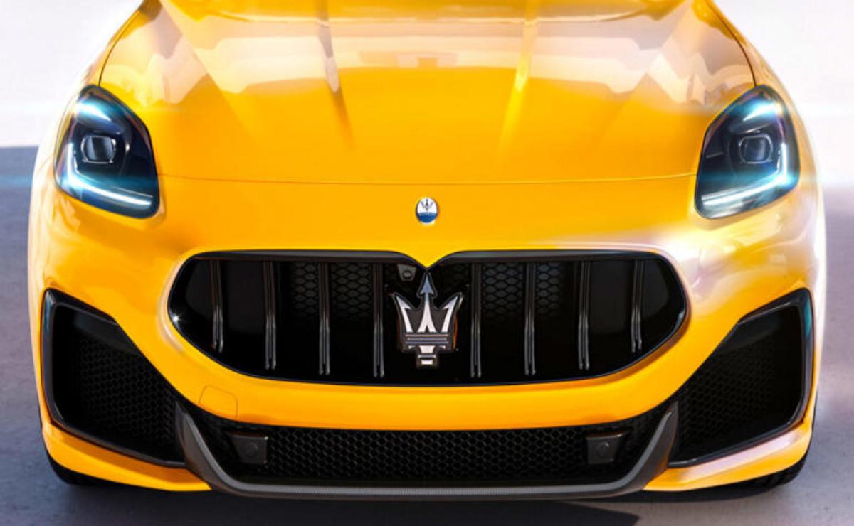 Close-up of a yellow Maserati grille with logo.