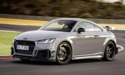 A sleek silver Audi sports car driving on a road.