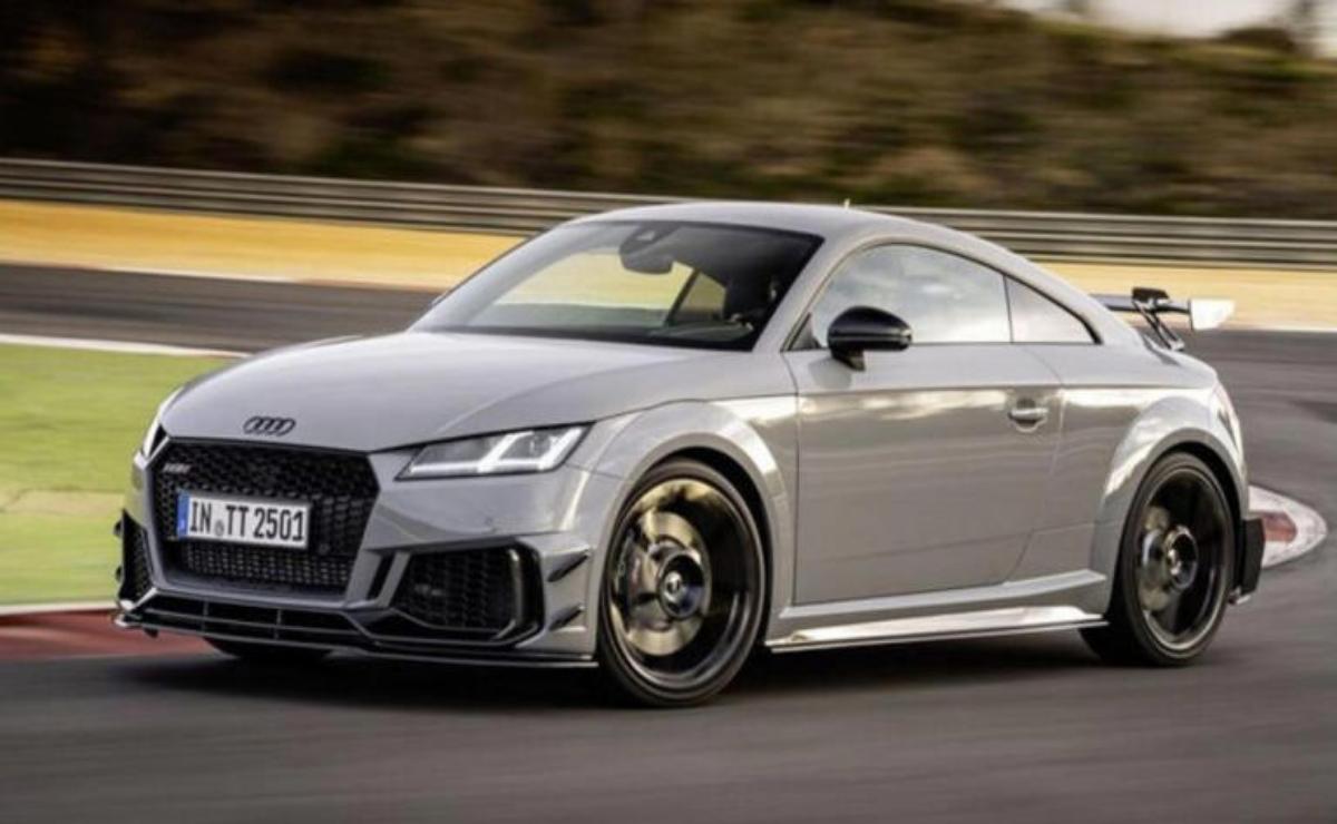 A sleek silver Audi sports car driving on a road.