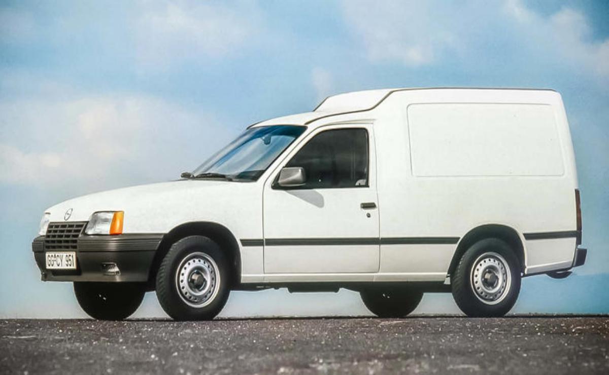 White compact cargo van parked outdoors against a cloudy sky.
