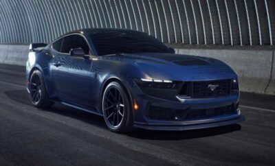 Sleek blue sports car parked inside a curved tunnel with dramatic lighting.