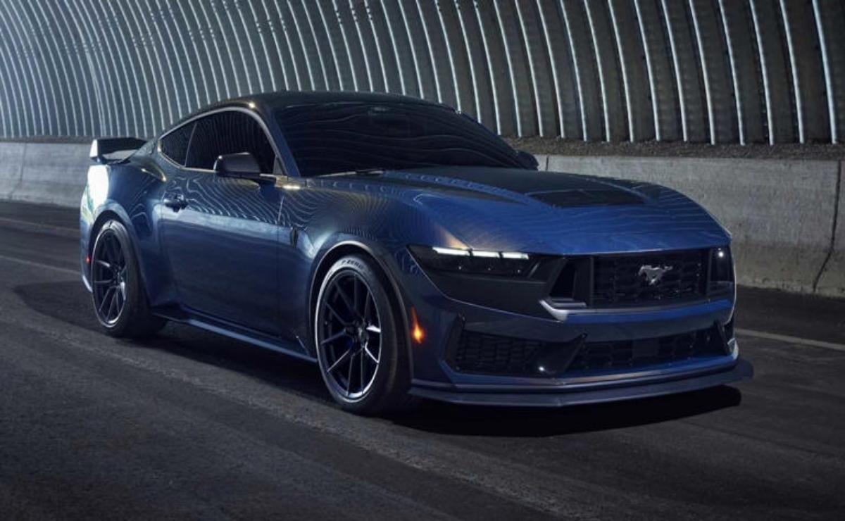 Sleek blue sports car parked inside a curved tunnel with dramatic lighting.