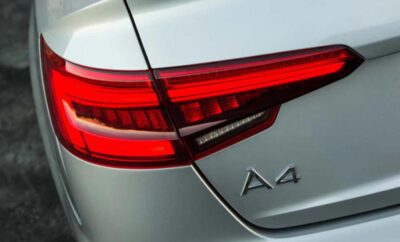Close-up of an Audi A4 rear light and badge on silver car.