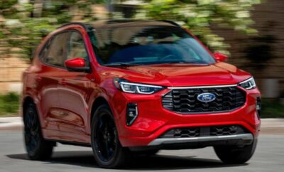 Red compact SUV driving on a road with blurred background.