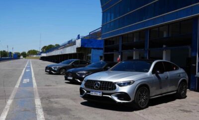 A lineup of luxury Mercedes-Benz cars parked outside a dealership.