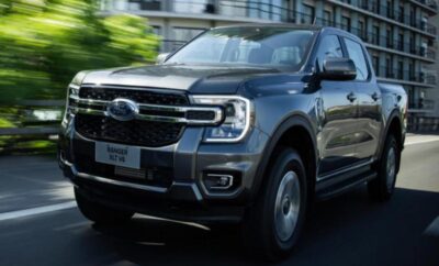 A sleek black Ford Ranger driving on a road in an urban setting.