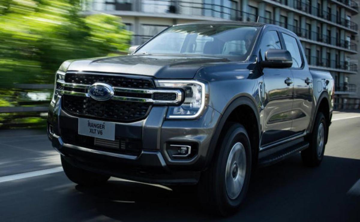 A sleek black Ford Ranger driving on a road in an urban setting.