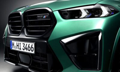 Close-up of a green sports car's front grille and headlight.
