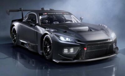 A sleek black sports car with aerodynamic design and glowing headlights.