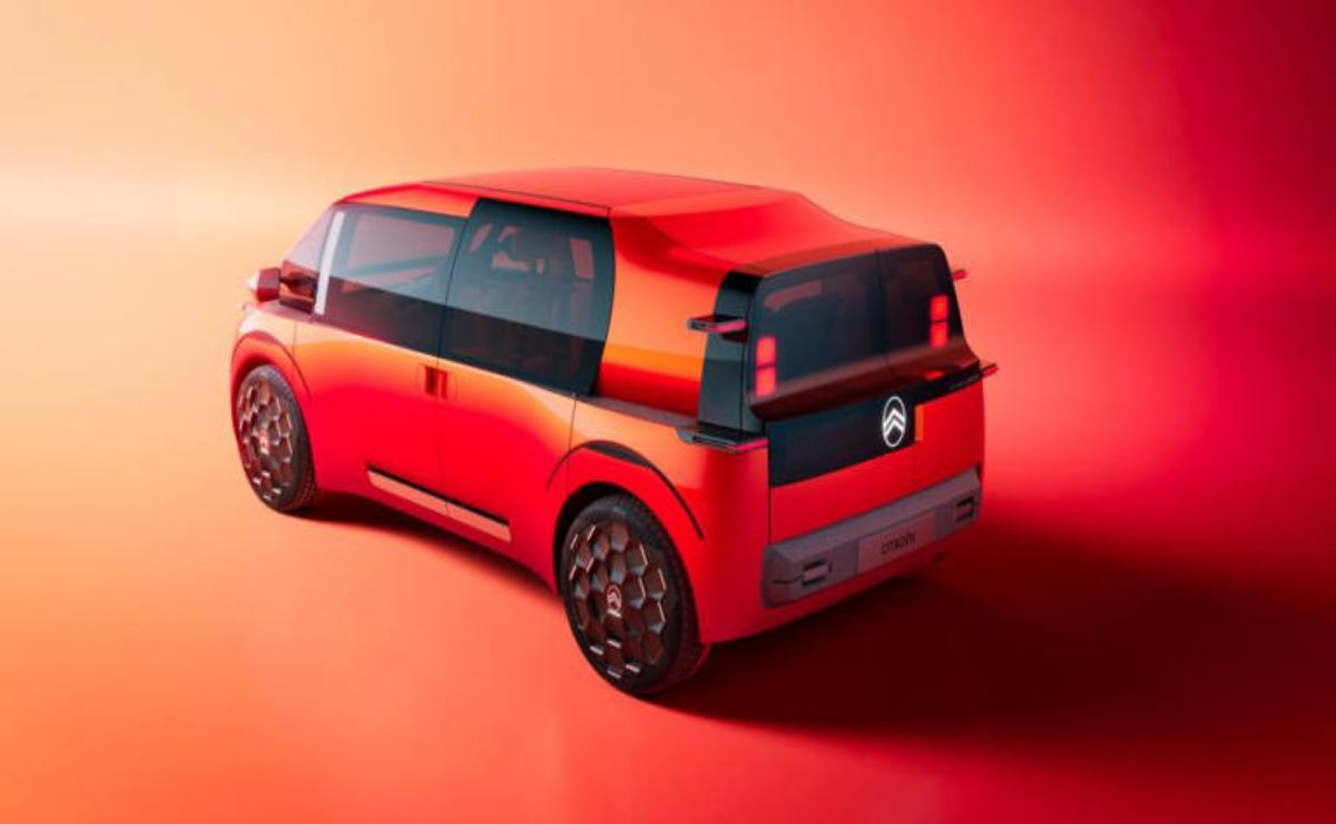 Futuristic compact electric car with sleek red and black design.