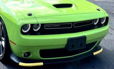 Close-up of a bright green Dodge Challenger front grille and headlights.