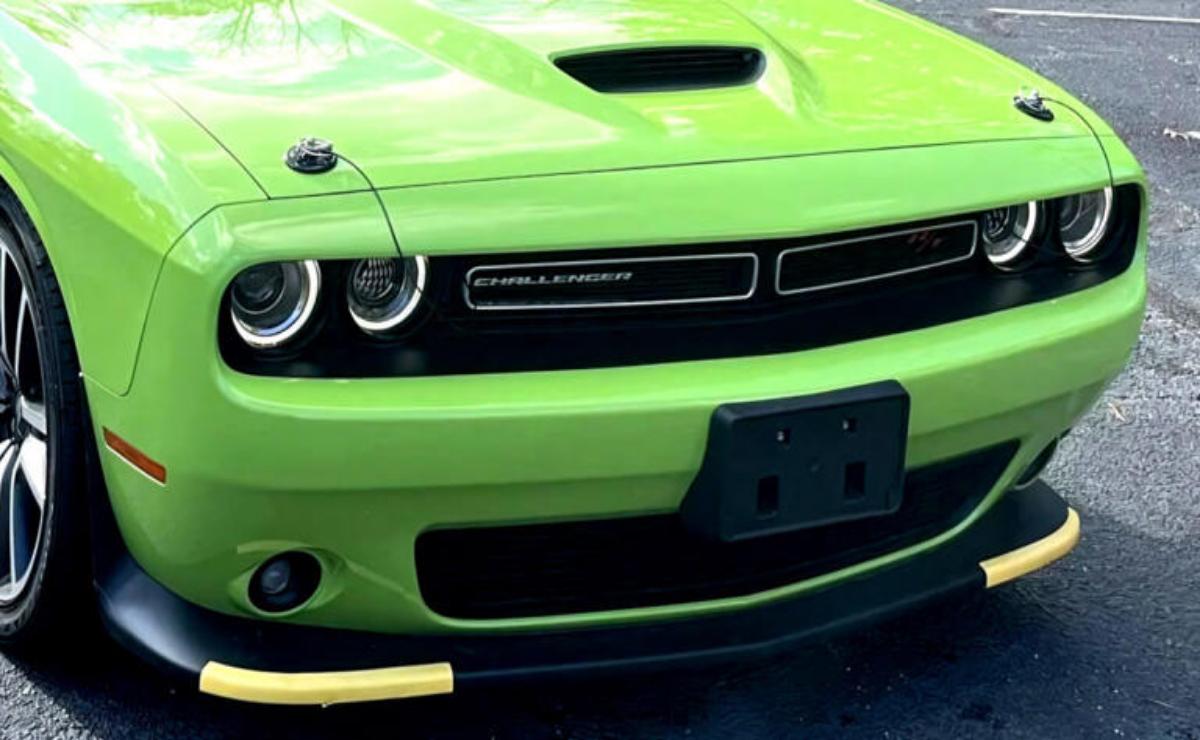 Close-up of a bright green Dodge Challenger front grille and headlights.