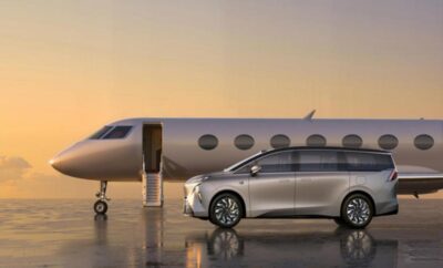 A sleek silver car parked beside a private jet at sunset.