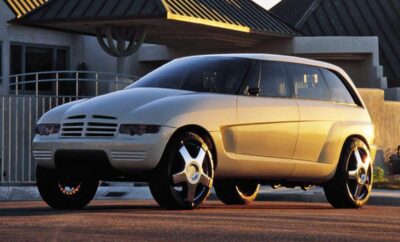 Futuristic silver car with sleek design and tinted windows at sunset.