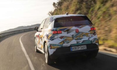 A colorful car with cartoon graphics driving on a road.