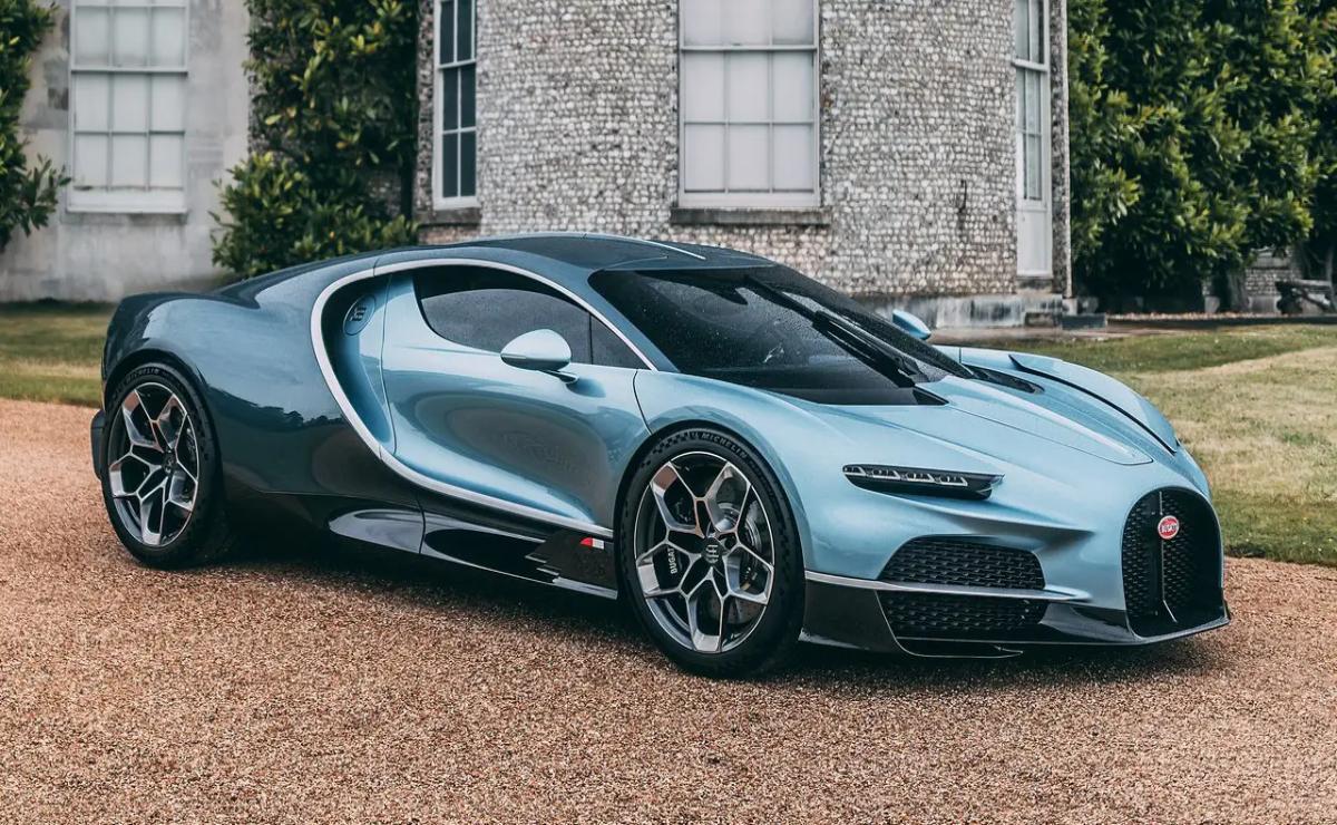 A sleek blue sports car parked in front of a stone building.