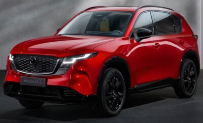Sleek red SUV with black accents under moody lighting.