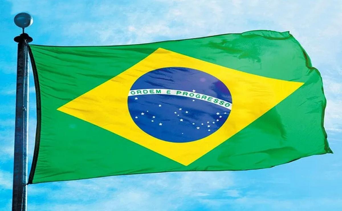 Brazilian flag waving against a blue sky.
