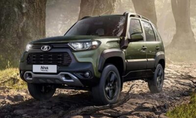 Green rugged SUV parked on rocky terrain under a cloudy sky.
