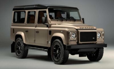 Classic beige Land Rover Defender with rugged black wheels.