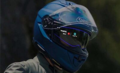 Person wearing a blue motorcycle helmet with a digital HUD display.