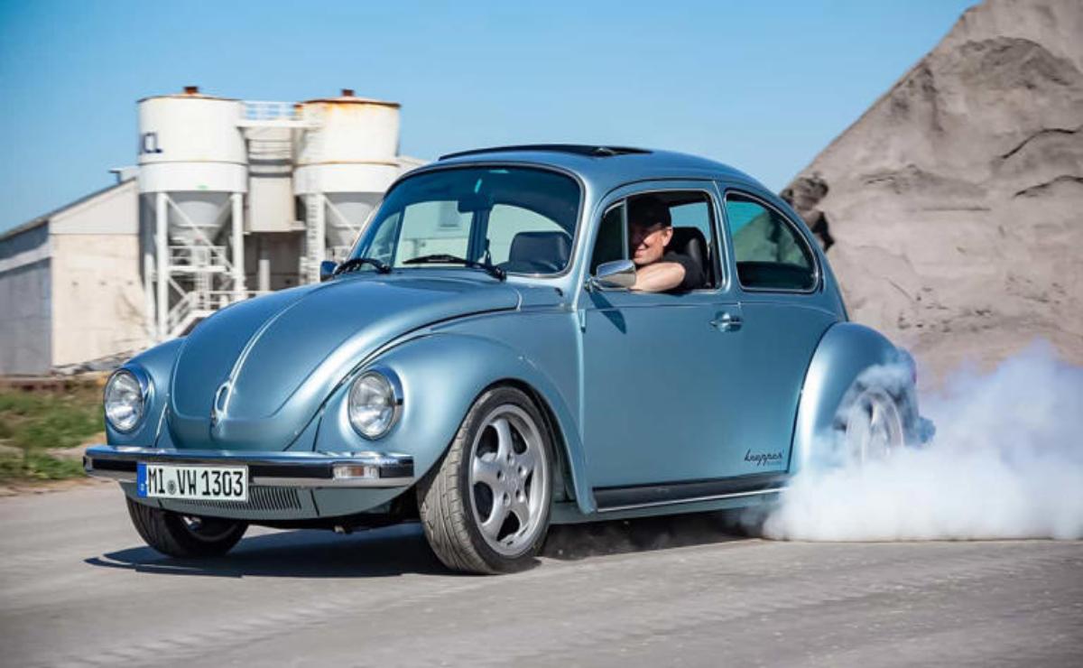 Classic blue Volkswagen Beetle performing a burnout.