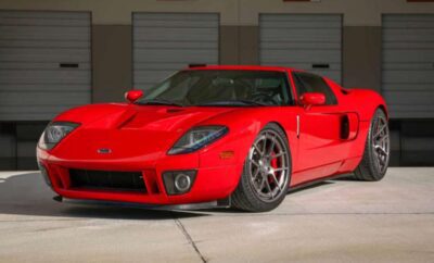 A red sports car parked in front of a garage.