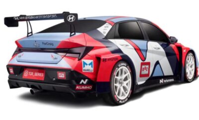 Side view of a red and white Hyundai race car with sponsor decals.