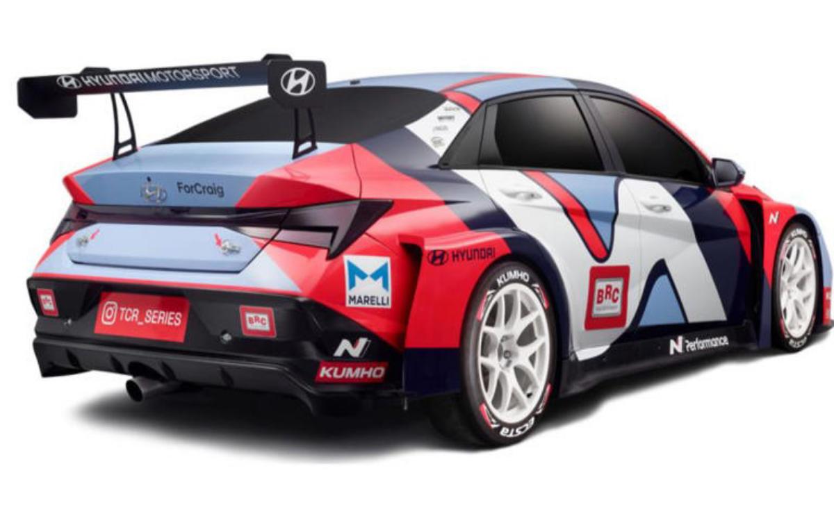 Side view of a red and white Hyundai race car with sponsor decals.