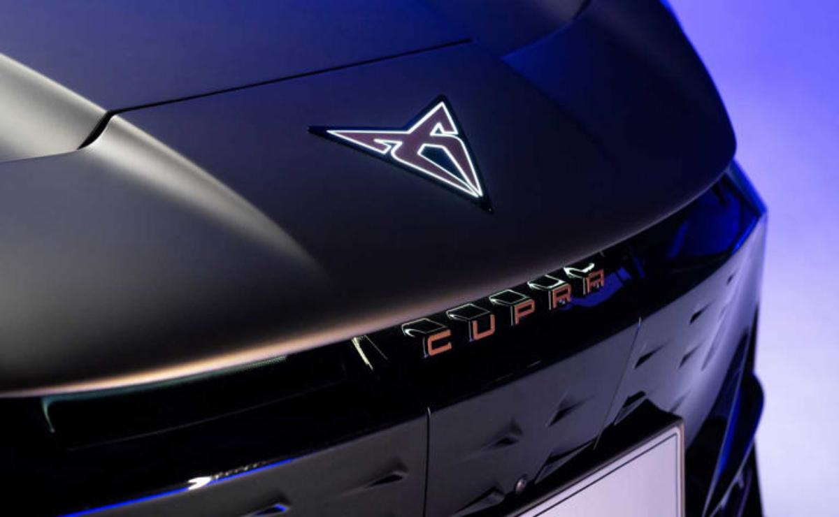 Close-up of a sleek black car hood with a futuristic logo.