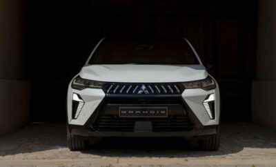 Front view of a white Mitsubishi Outlander SUV in a dark setting.