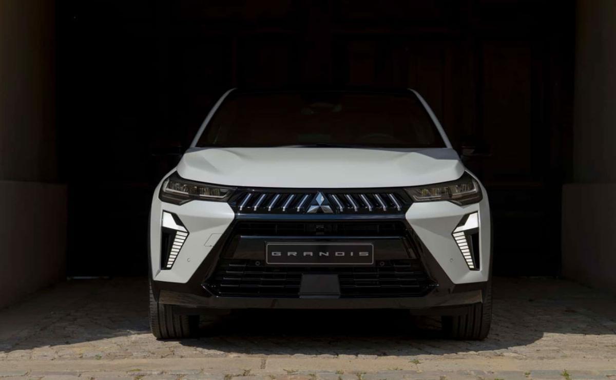 Front view of a white Mitsubishi Outlander SUV in a dark setting.