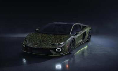 Sleek black sports car with glowing green accents in a dark setting.