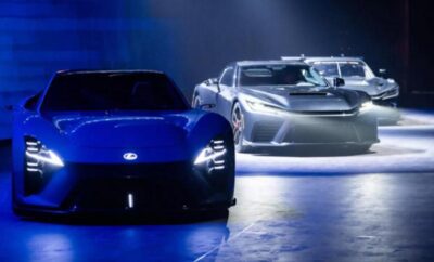 Two futuristic concept cars showcased under dramatic lighting in a dark setting.