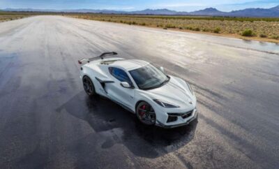 Sleek white sports car parked on a vast desert runway under a clear sky.