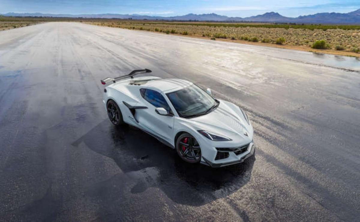 Sleek white sports car parked on a vast desert runway under a clear sky.