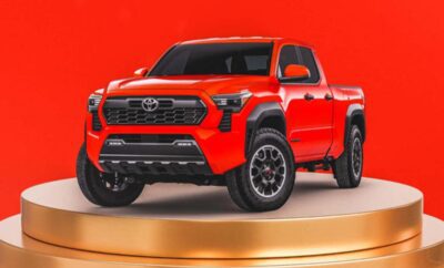 Bright orange pickup truck displayed on a golden platform.