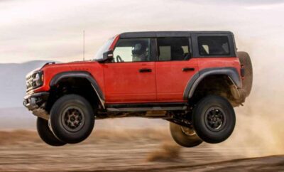 Red off-road SUV jumping over rough terrain.